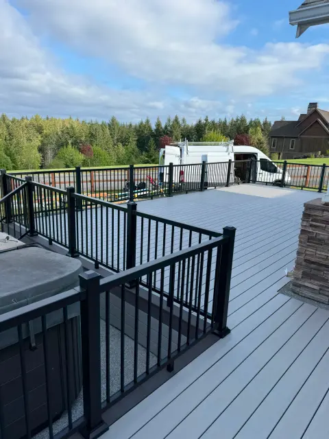 Deck with hot tub, stone column and black railing